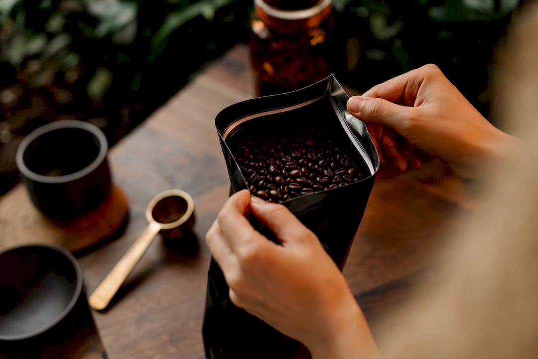 Hands opening fresh coffee roast bag